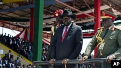 FILE - South Sudan's President Salva Kiir, center, accompanied by army chief of staff Paul Malong Awan, right, attends an independence day ceremony in the capital Juba, South Sudan, July 9, 2015.