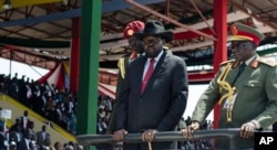 FILE - South Sudan's President Salva Kiir, center, accompanied by army chief of staff Paul Malong, right, attends an independence day ceremony in the capital Juba, South Sudan, July 9, 2015.