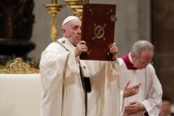 El Papa Francisco sostiene el libro de los Evangelios mientras celebra la misa de Nochebuena en la Basílica de San Pedro en el Vaticano, el martes 24 de diciembre de 2019.
