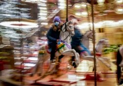 A girl rides on a merry-go-round on the first day of the Christmas market in Frankfurt, Germany, Nov. 22, 2021.