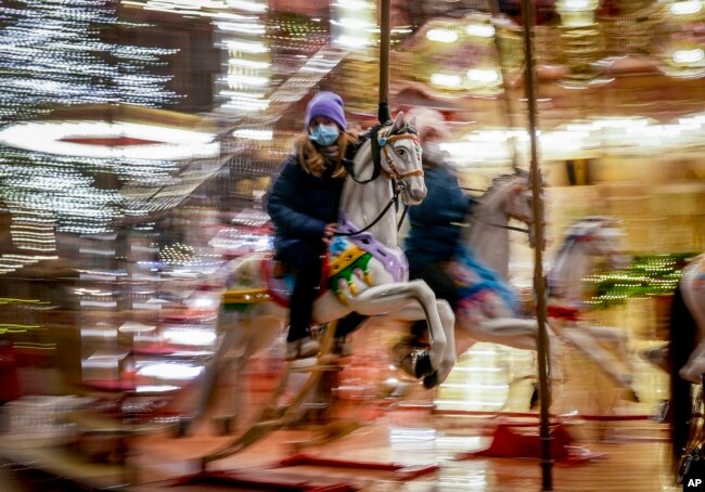 A girl rides on a merry-go-round on the first day of the Christmas market in Frankfurt, Germany, Nov. 22, 2021.