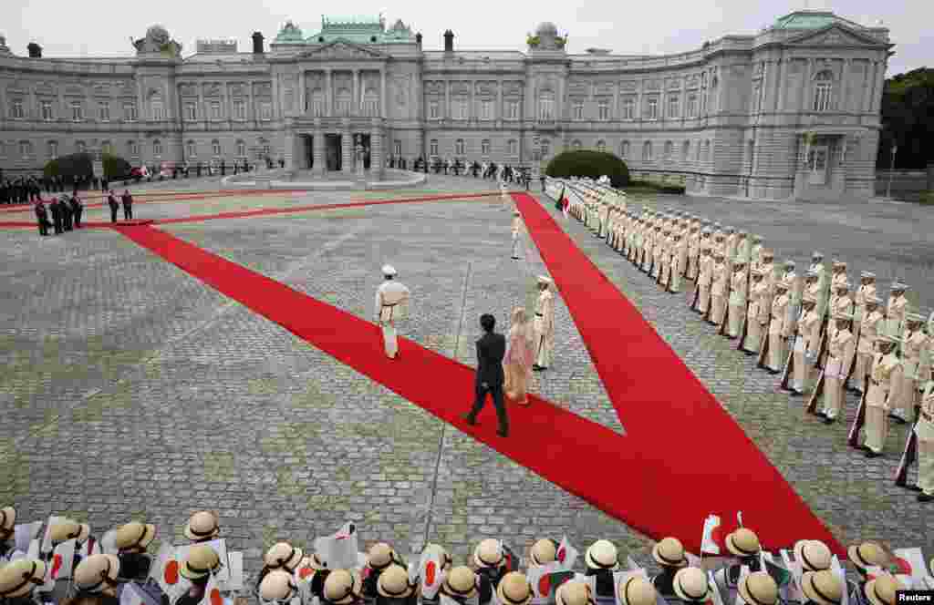 Bangladesh&#39;s Prime Minister Sheikh Hasina (center, R) and Japan&#39;s Prime Minister Shinzo Abe (centre, L) walk as they attend a welcoming ceremony at the state guest house in Tokyo.