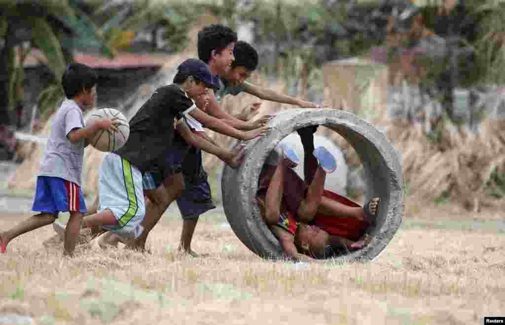 Boys play with a drainage culvert used for flood control in Las Pinas, Metro Manila, the Philippines.