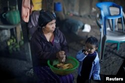 Catarina Alonzo, mother of Felipe Gomez Alonzo, dekernels maize at her home in the village of Yalambojoch, Guatemala, Dec. 27, 2018.