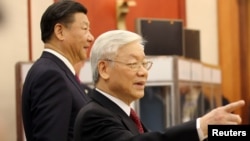 Tổng Bí thư Nguyễn Phú Trọng (phải) vừa được Ban Chấp hành TƯ Đảng giới thiệu vào chức Chủ tịch nước. Mô hình nhất thể hóa hai chức danh này đang được Trung Quốc áp dụng với ông Tập Cận Bình (trái) đang nắm giữ cả hai chức vụ trên.
