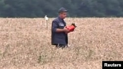 En la imagen se observa un individuo con lo que se estima sería una caja negra del avión malasio que cayó en Ucrania.