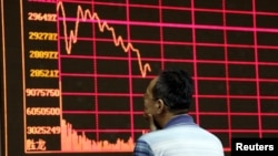 Nhà đầu tư nhìn vào bảng hiển thị thông tin chứng khoán điện tử của thị trường chứng khoán Thượng Hải tại Trung tâm môi giới chứng khoán ở Bắc Kinh.