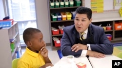 Houston Independent School District Superintendent Richard Carranza, right, talks with second grader John Bradford, 7, after handing out breakfast to students on their first day of school at Codwell Elementary School, Sept. 11, 2017, in Houston.