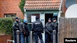 Danish police conduct a search at an apartment at Mjoelnerparken at Norrebro in connection with Saturday's shootings, Feb. 15, 2015.