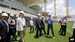 Jerome Valcke, secretario general de la FIFA (centro) y otras personalidades visitan el estadio Arena de Sao Paulo, durante una gira de inspección de los escenarios del Mundial 2014.