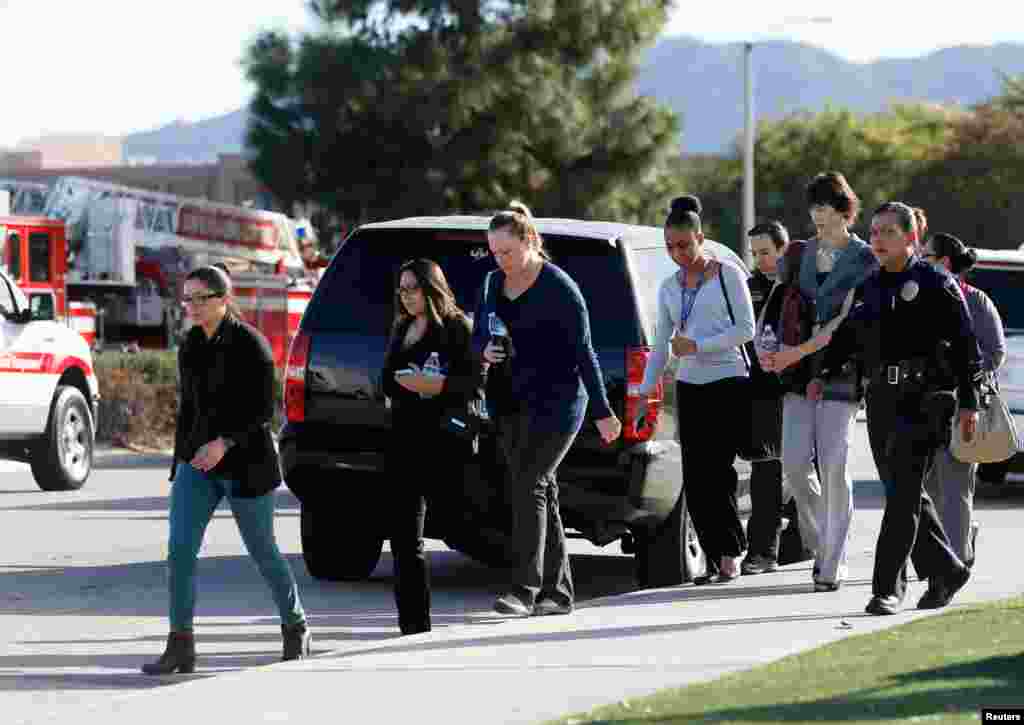 Polisi mengawal warga ke luar dari lokasi saat mengamankan lokasi penembakan di San Bernardino, California (2/12). (Reuters/Mario Anzuoni)