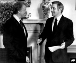 FILE - Then-Vice President Mondale, right, briefs President Jimmu Carter on his trip to Europe in the Oval Office In Washington, May 24, 1977.