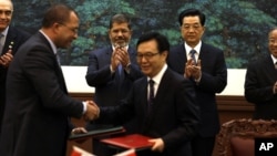 Egyptian President Mohammed Morsi, center left, and Chinese President Hu Jintao, center right, applaud as officials exchange documents during a signing ceremony in Beijing, China, August 28, 2012.