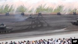 Tank milik Pasukan Darat Bela Diri Jepang mengepulkan asap dalam latihan menembak tahunan di wilayah Higashi Fuji, Gotemba, barat daya Tokyo, Selasa, 20 Agustus, 2013. (AP Photo / Koji Sasahara)