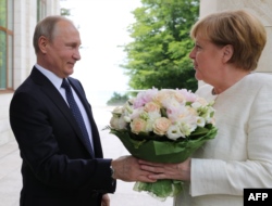 Russian President Vladimir Putin (L) welcomes German Chancellor Angela Merkel during their meeting in Sochi.