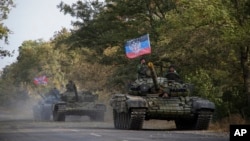 FILE - Russia-backed rebel tanks with a flag of the self-proclaimed Donetsk People's Republic are seen near Novoazovsk, eastern Ukraine, Oct. 21, 2015.