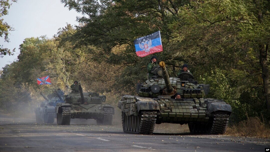 FILE - Russia-backed rebel tanks with a flag of the self-proclaimed Donetsk People's Republic are seen near Novoazovsk, eastern Ukraine, Oct. 21, 2015.