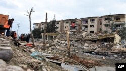 FILE - Rescue workers are seen at the scene of a traffic police station and lodging quarters attacked with a car bomb by Kurdish rebels, in Nusaybin, southeastern Turkey, March 4, 2016.