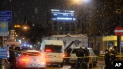 Turkish security gather outside a police station where one police officer was killed and another injured after a suicide bomber blew herself up in Istanbul.