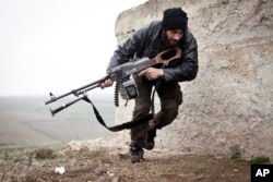 FILE - A Free Syrian Army fighter takes cover during fighting with the Syrian Army in Azaz, Syria.