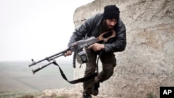 FILE - A Free Syrian Army fighter takes cover during fighting with the Syrian Army in Azaz, Syria. 