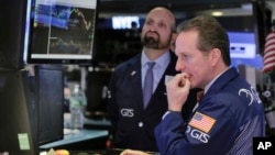 Specialists Glenn Carell (R), and James Denaro work on the floor of the New York Stock Exchange, March 27, 2017. Banks and industrial companies are leading stocks lower on Wall Street in early trading. 