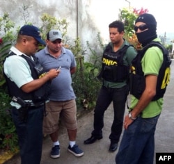 National Police agents escort Plutarco Antonio Ruiz (2nd-L), the boyfriend of Miss Honduras Maria Jose Alvarado's sister, in Santa Barbara, 200 kms north of Tegucigalpa, Nov. 18, 2014.