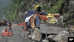 Workers try to salvage items from a supply truck loaded with cement bags on a highway near the northeastern Indian city of Gangtok after it was damaged during Sunday's 6.9 magnitude earthquake, September 20, 2011.