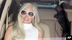 Lady Gaga dalam pakaian dan aksesoris berwarna putih tiba di bandara LAX dikawal bodyguard di Los Angeles, 17 Februari 2015.
