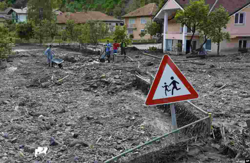 Residents walk on streets covered with mud and rubble after a landslide at the village of Topcic Polje, near Zenica, Bosnia-Herzegovina, May 20, 2014.