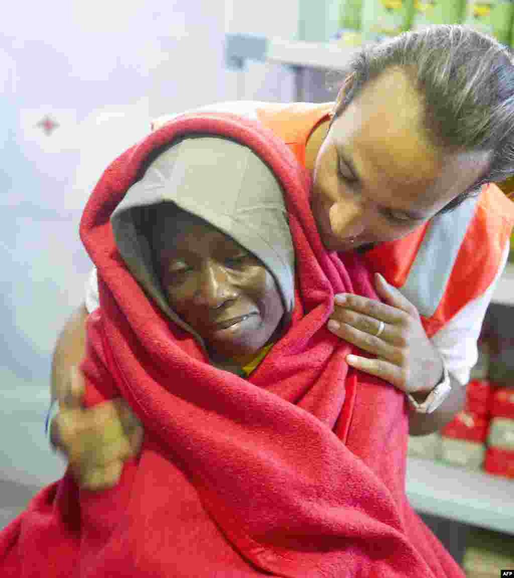 A member of the Red Cross tends to a would-be immigrant wrapped in a blanket at the Red Cross premises at Tarifa&#39;s harbor, Italy after 86 would-be immigrants were rescued across the Straight of Gibraltar.