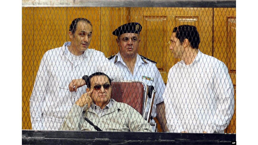 FILE - former Egyptian president Hosni Mubarak, seated, and his two sons Gamal Mubarak (L) and Alaa Mubarak (R) are seen attending a hearing in a Cairo courtroom Sept. 14, 2013.
