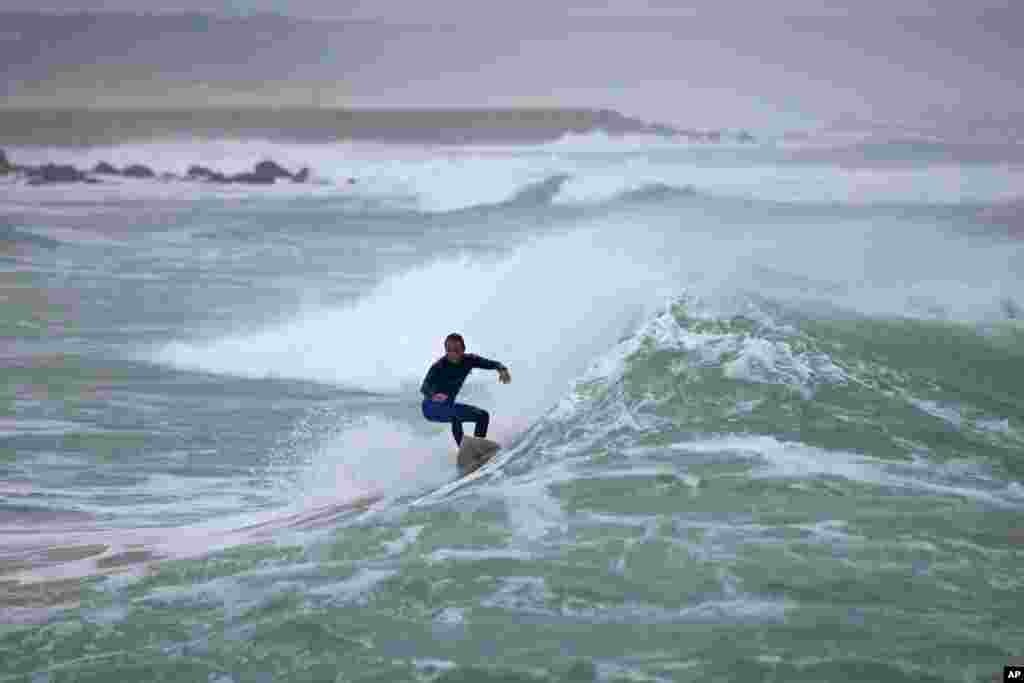 A surfer rides a wave at Costa da Caparica beach in Almada, outside Lisbon. Portugal is popular with bodyboarders and surfers, especially during the winter months when big swells hit its Atlantic coast.