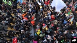 Ribuan migran Amerika Tengah mendengarkan penjelasan dari para pejabat Meksiko di kota Tijuana, Kamis (22/11). 