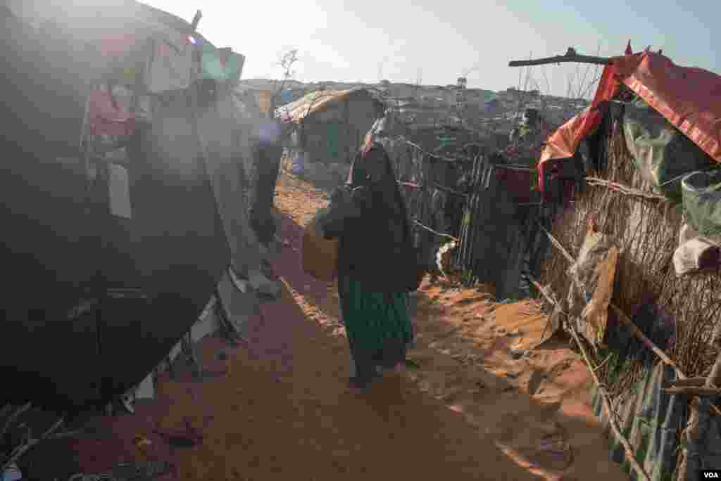 A girl carries a baby boy in a camp in Kismayo, Somalia that is home to both displaced Somalis and returned refugees on September 27, 2016. (J. Patinkin/VOA)