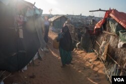 FILE - A girl carries a baby boy in a camp in Kismayo, Somalia that is home to both displaced Somalis and returned refugees on September 27, 2016. (J. Patinkin/VOA)