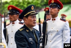 Chinese Defense Minster Wei Fenghe inspects the honor guard during a welcoming ceremony at the Ministry of Defense in Singapore, May 29, 2019.