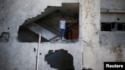 Palestinians look out of their house that was damaged in an Israeli air strike, in Gaza City, Nov. 13, 2018. 