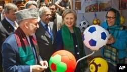 Afghan President Hamid Karzai and U.S. Secretary of State Hillary Rodham Clinton tour a crafts bazaar in Kabul as they attend an international conference on Afghanistan.