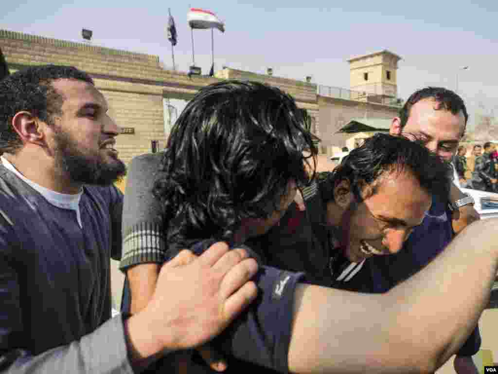 Para tahanan politik berpelukan saat dibebaskan dari penjara di Kairo (14/3). (VOA/H. Elrasam)