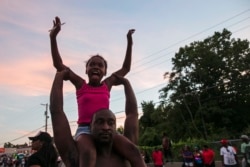 Ilustrasi. Seorang gadis duduk di atas bahu ayahnya, selama demonstrasi damai, ketika masyarakat bereaksi terhadap penembakan Michael Brown di Ferguson, Missouri 14 Agustus 2014. (Foto: REUTERS)