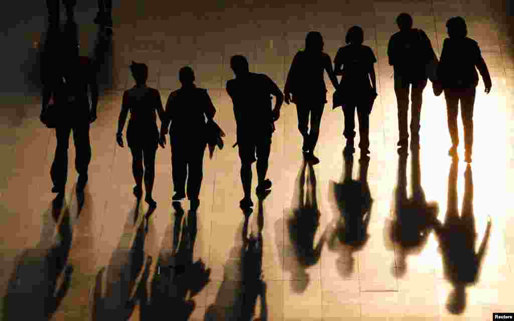 Visitors' shadows cast as they stroll through the ExCel arena in London.
