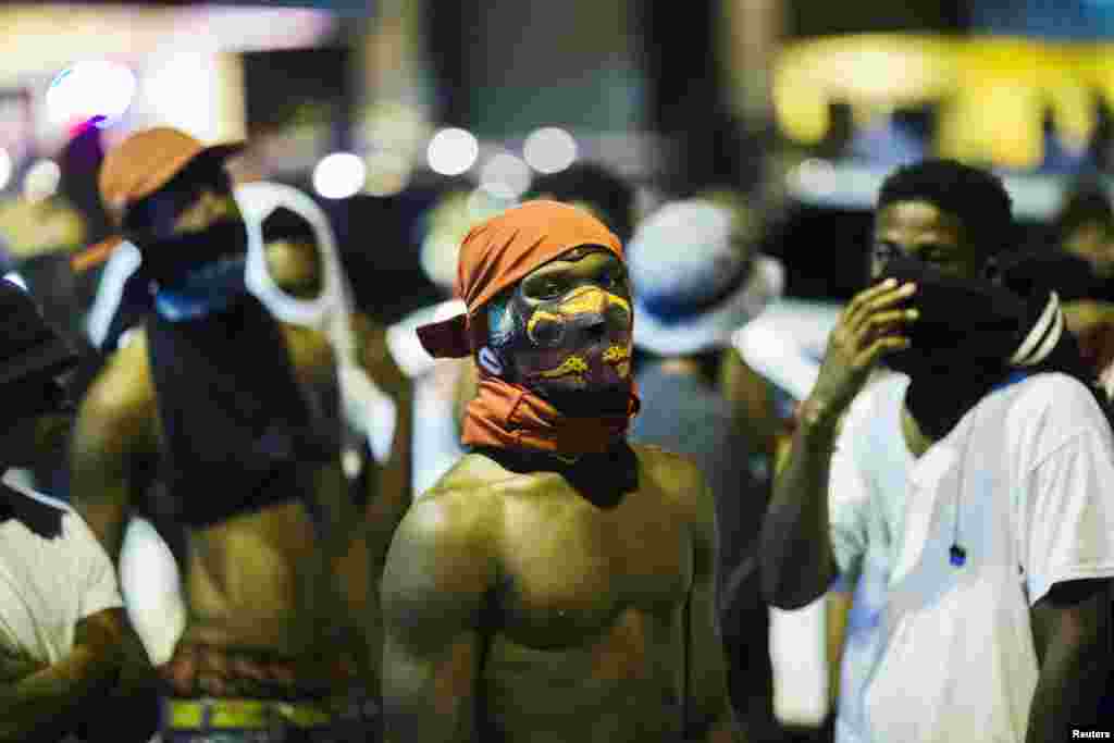 Young men stand in the streets during another night of demonstrating in Ferguson, Missouri, Aug. 12, 2015.