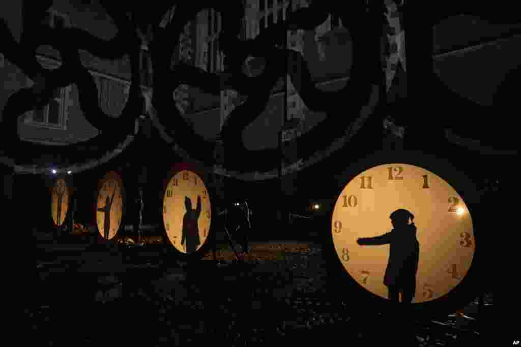 Visitors interact with a clock-lighting ceremony on the "Palace of Stardust" light trail held for the Christmas season at Hampton Court Palace in London, Dec. 7, 2021.