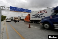 FILE - Trucks wait in the queue for customs control to cross into the U.S. at the World Trade Bridge in Nuevo Laredo, Mexico, Nov. 2, 2016.