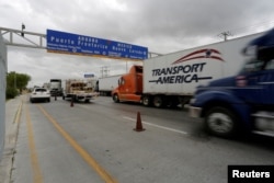 FILE - Trucks wait in the queue for border customs control to cross into the U.S. at the World Trade Bridge in Nuevo Laredo, Mexico, Nov. 2, 2016.