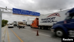 FILE - Trucks wait in the queue for border customs control to cross into the U.S. at the World Trade Bridge in Nuevo Laredo, Mexico on Nov. 2, 2016.