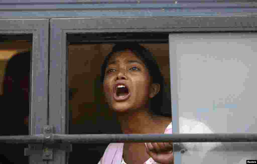 A demonstrator shouts slogans from inside a bus after she was detained by police near the presidential palace during a protest rally in New Delhi, India, December 21, 2012. 