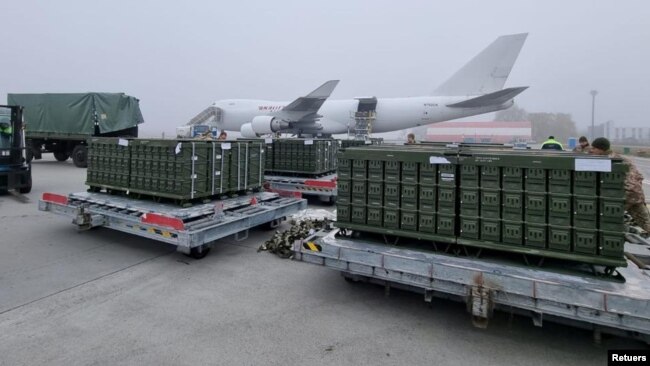 Workers and Ukrainian servicemen unload a shipment of ammunition delivered as part of U.S. security assistance to Ukraine, at the Boryspil International Airport outside Kyiv, Ukraine November 14, 2021. (Press service of the U.S. Embassy in Ukraine/Handout