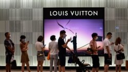 CHINA – customers wearing face masks wait in line to enter a shop in a shopping mall in Wuhan, China's central Hubei province, on Sept. 5, 2020.